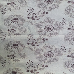 Large stylized two tone floral motifs are outlined with thick, rope-like embroidery, giving it a 3D effect on a linen look fabric base.