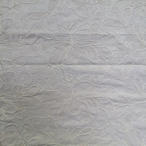 Large stylized floral motifs are outlined with thick, rope-like embroidery, giving it a 3D effect on a natural colour linen look fabric base.
