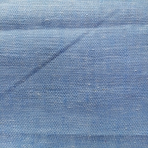 A light blue shade with a heathered or multi-tonal look on a surface with natural slubs and irregular threads, very characteristic of linen.