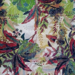 Botanical print fabric with a dense, layered tropical foliage design in deep burgundy, olive and moss green, mustard gold and cream, featuring large serrated leaves, trailing ferns, small clustered berries, and stylized flower motifs on a light, subtly textured woven ground; a painterly, hand-blocked style with visible fabric grain running vertically through the print.