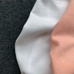 CHARCOAL, WHITE & SOFT PINK COLOURED FABRICS DISPLAYED VERTICALLY.