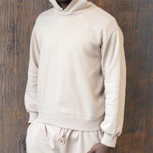 MALE MODEL DRESSED IN A WHITE FLEECE HOODIE AND TRACKPANT