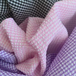 DIFFERENT GINGHAM CHECK TEXTURED FABRIC DRAPED NEXT TO EACH OTHER