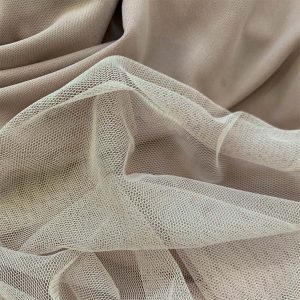 TONAL NUDE COLOURED FABRICS, A TULLE AND SATIN, DISPLAYED HORIZONTALLY.