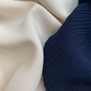 A WHITE AND A BLUE COLOUR WOVEN FABRICS DRAPED NEXT TO EACH OTHER.