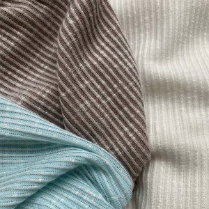DIFFERENT COLOURS, TEXTURED KNITTED RIB FABRICS DRAPED NEXT TO EACH OTHER