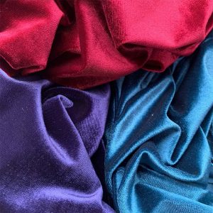 DIFFERENT COLOURED VELOUR FABRIC DRAPED NEXT TO EACH OTHER