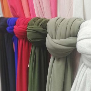 DIFFERENT COLOURS KNITTED VISCOSE LYCRA ON DISPLAY USING A KNOT TO SECURE EACH DISPLAY ITEM.