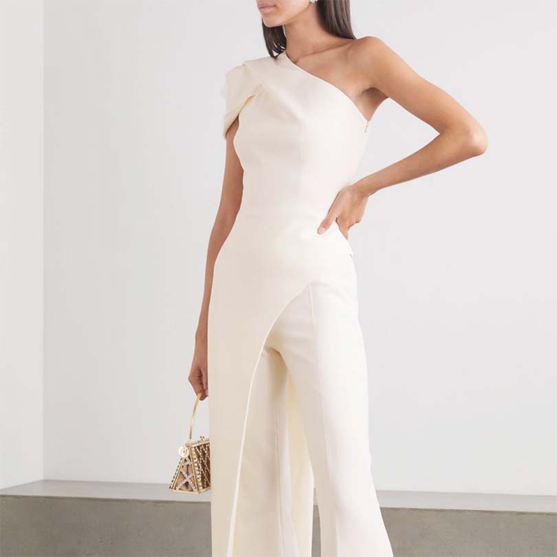 Model dressed in modern cream colour, one shoulder fitted tailored pant suit