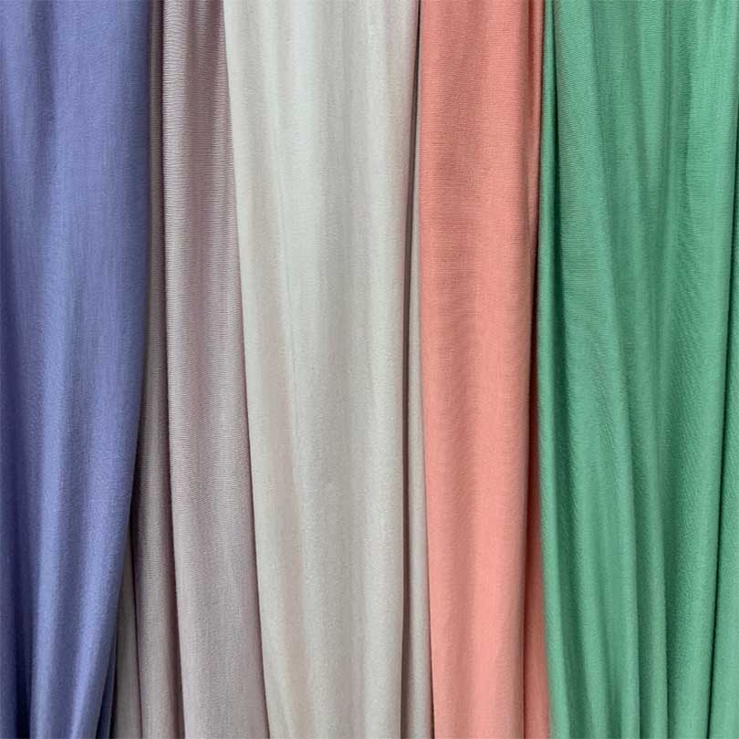 5 different colour fabrics in a hanging display next to each other.