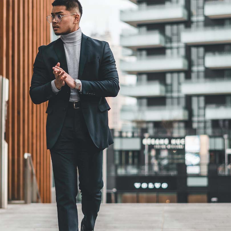 Young professional walking in a city street, dressed in suit for office.