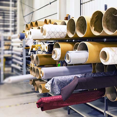 Multiple fabric rolls stored in stacked cylindrical units.